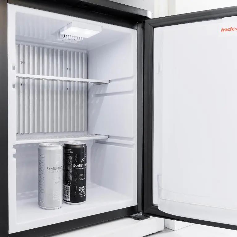 Minifrigo della camera con bibite in lattina