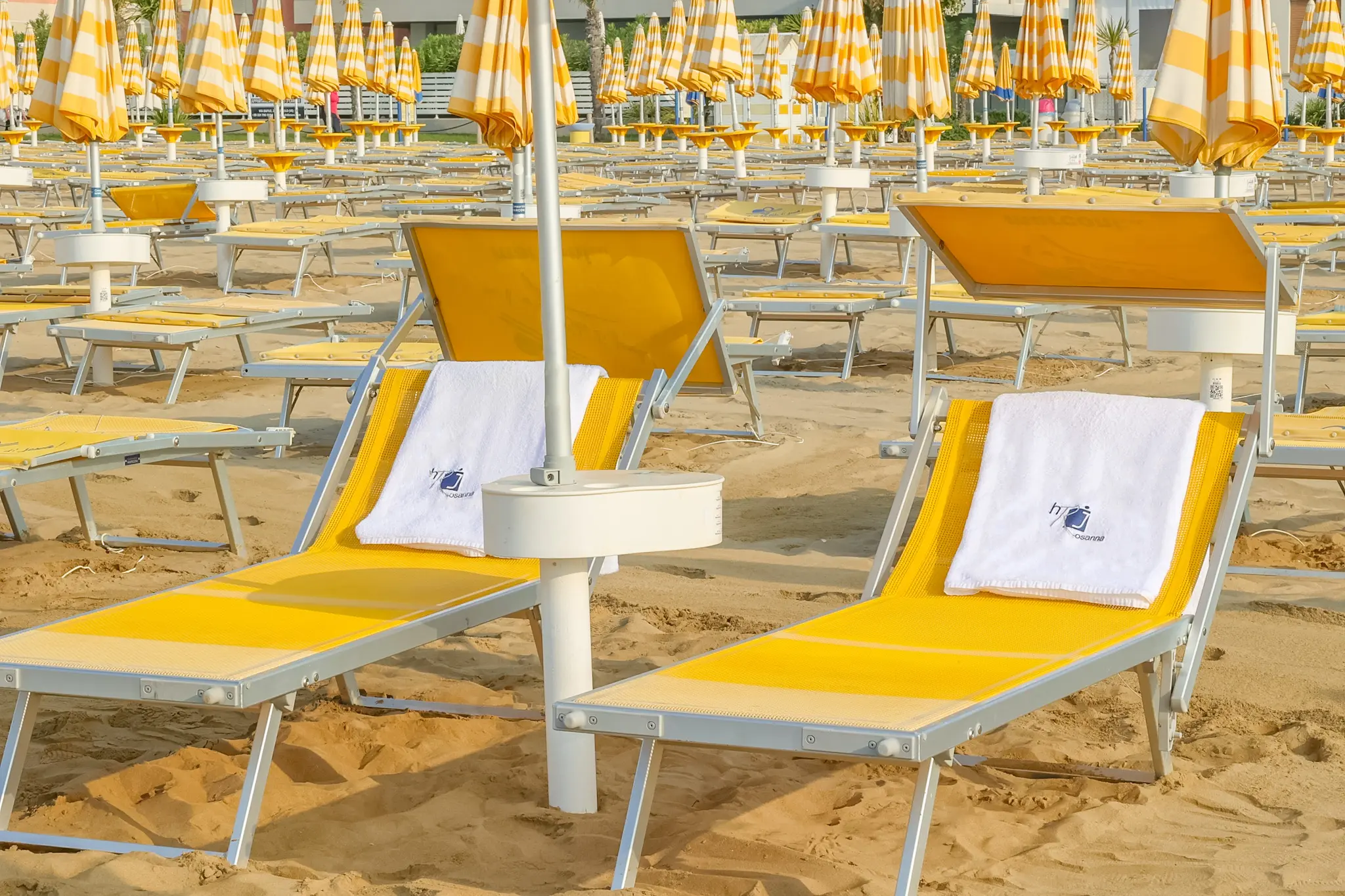 Lettini con teli dell'Hotel Rosanna nella spiaggia privata